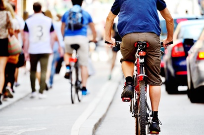 Cyclists cycle along busy road 
