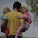 Image of man carrying his two children