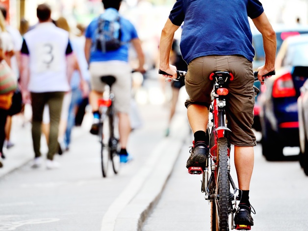 Cyclists cycle along busy road 