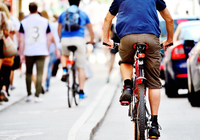 Cyclists cycle along busy road 