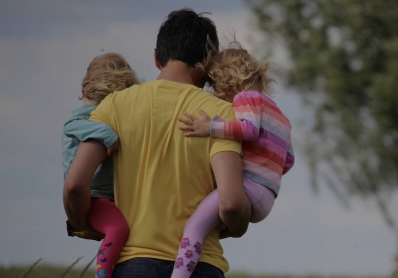 Image of man carrying his two children