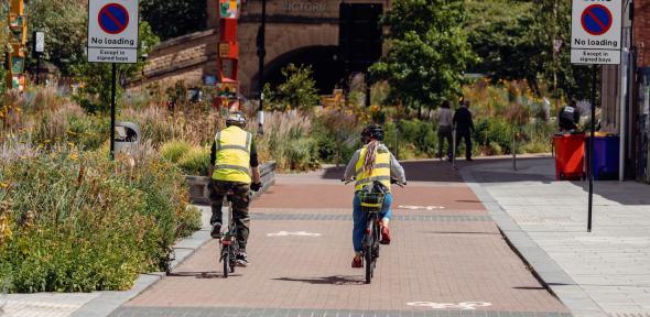 Credit: Photo by <a href="https://unsplash.com/@benjaminelliott?utm_content=creditCopyText&utm_medium=referral&utm_source=unsplash">Benjamin Elliott</a> on <a href="https://unsplash.com/photos/a-couple-of-people-riding-bikes-down-a-sidewalk-T49ouJiApzU?ut